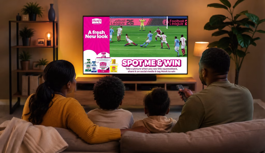 Family watching a television advertisement during a live football match, illustrating the impact of TV advertising and media buying in Kenya.